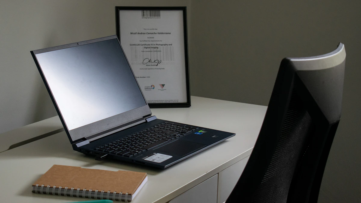 Laptop and spiral notebook on a desk beside an office chair.